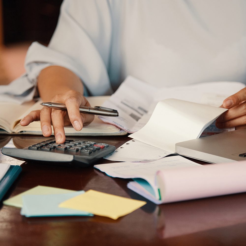 A person working at a desk with a pen and paperwork